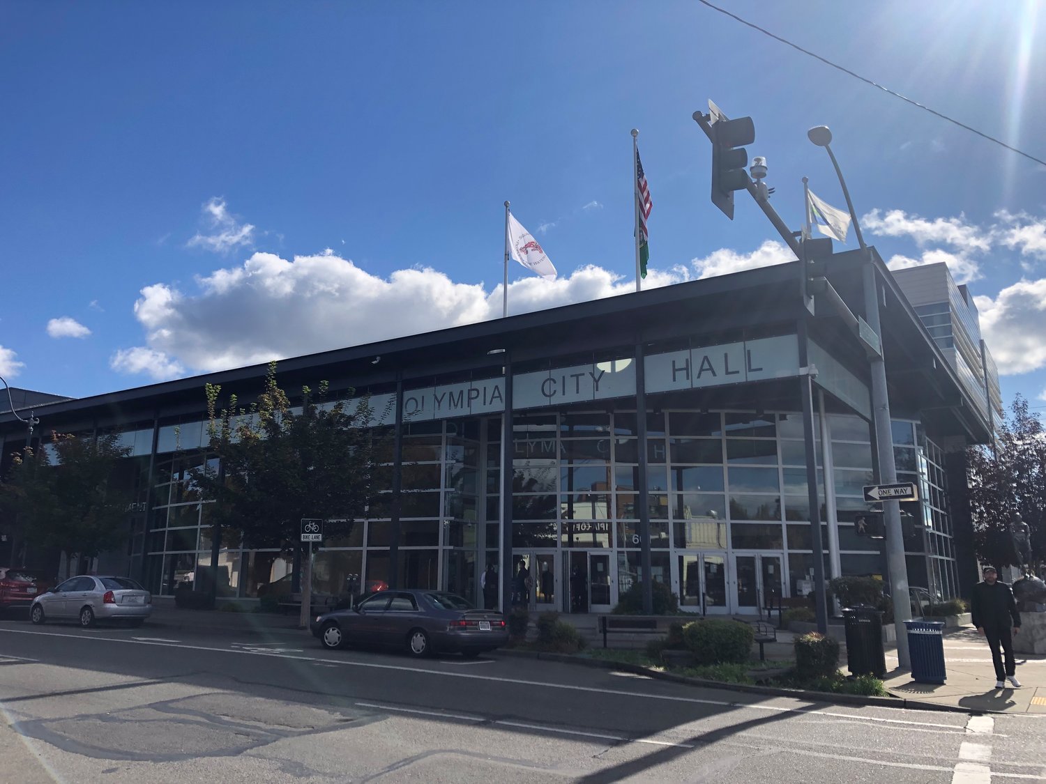 The Squaxin Island Tribe's flag flies on the left pole, the U.S. and Washington flags on the center pole and the City of Olympia flag flies on the right pole following a ceremony on Oct. 7, 2021 at Olympia City Hall.