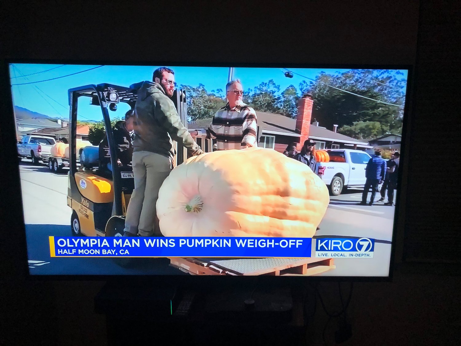 Jeff Uhlmeyer's giant pumpkin is escorted to the weighing platform, as shown on KIRO7 News on Oct. 12, 2021.