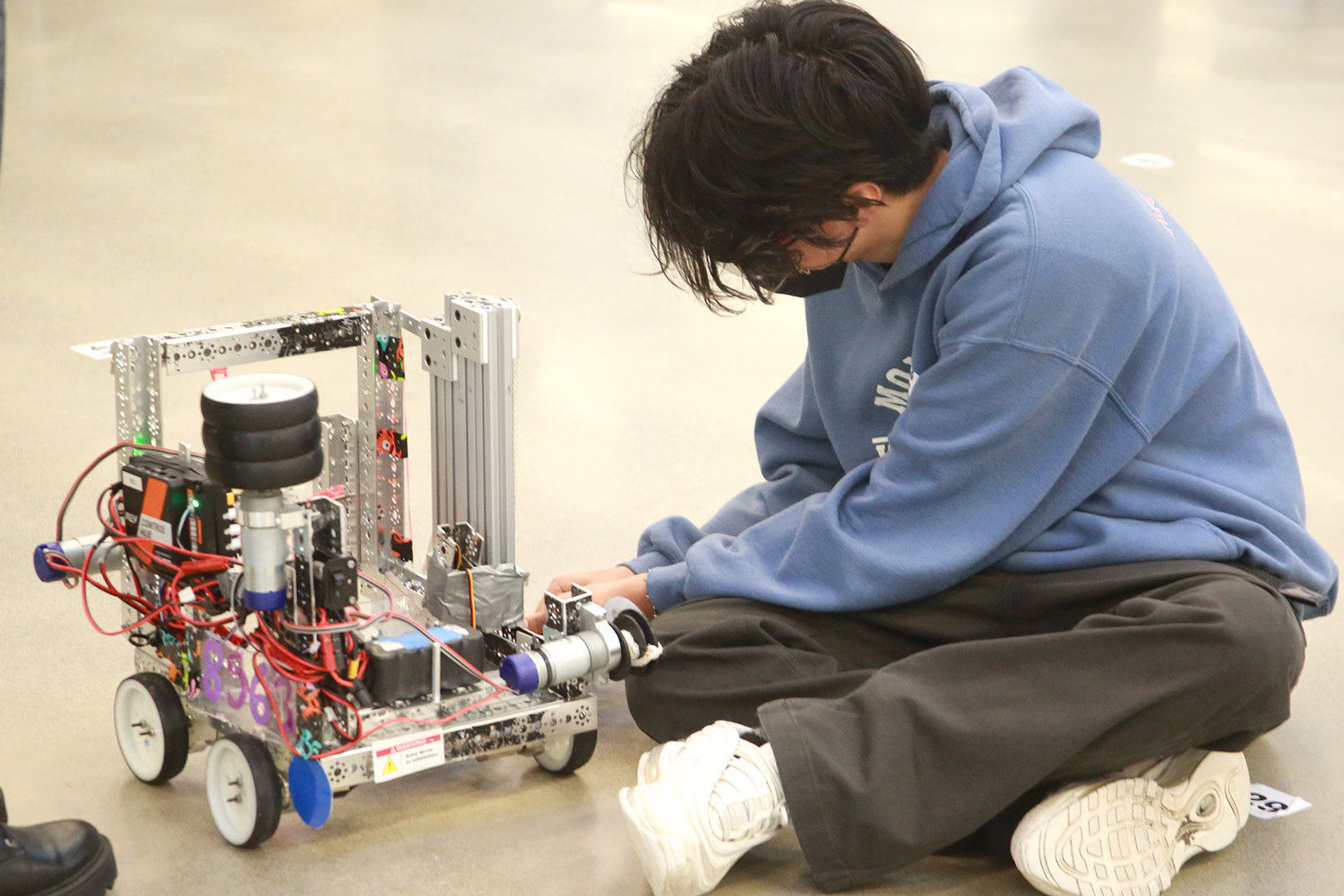 Josue Rios, from North Thurston High School, adjusts his robot at the Nov. 13, 2021 competition.