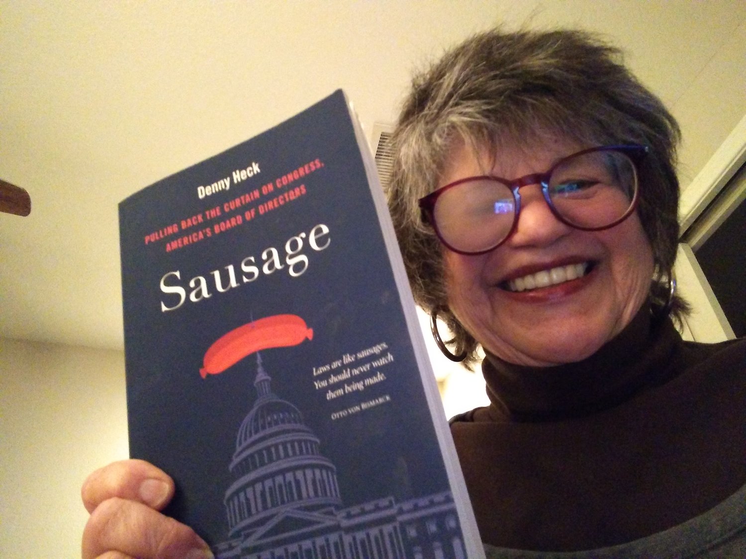 Marcia Hamilton is shown holding a rare paperbound copy of "Sausage," by Denny Heck