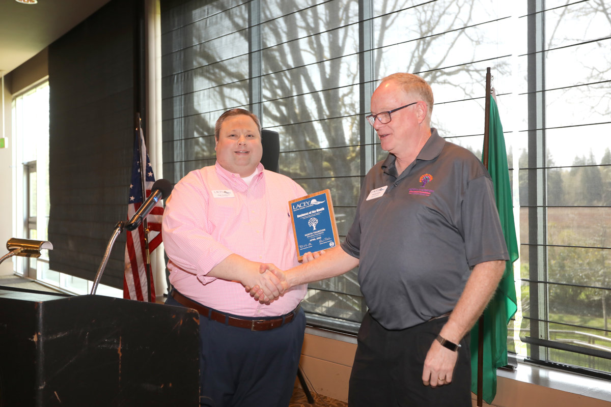 Mike Jones, right, executive director of the North Thurston Education Foundation, accepts the Lacey South Sound Chamber's Business of the Month Award from Blake Knoblauch, the chamber's executive director, on April 4, 2022.
