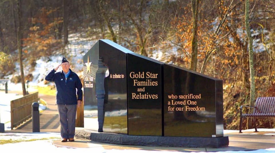 Congressional Medal of Honor awardee Hershel “Woody” Williams is shown in front of one of the Gold Star Memorial monuments.