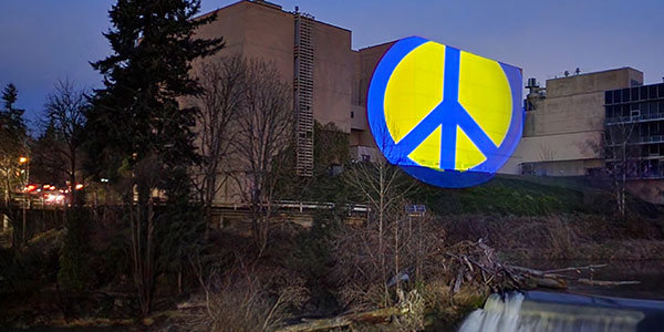 This is not a Photoshop'd image -- it's an extended shutter photo of an image that's being projected onto one of the old Olympia Brewing Company buildings. Peace for Ukraine, in the nation's colors.