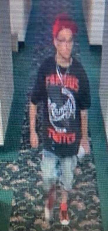 The suspect in the gun theft was pictured wearing a red cap, black graphic t-shirt, light-colored jean shorts, and red sneakers.